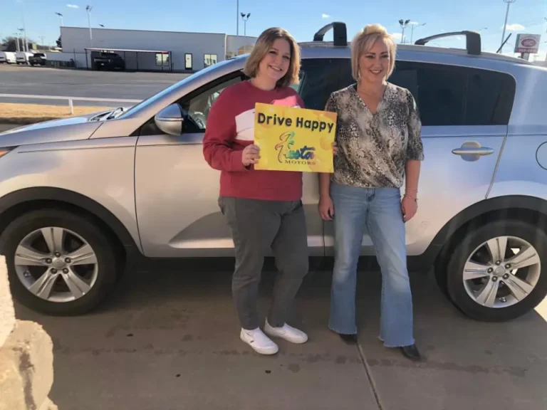 Excited customers posing with their newly bought vehicle.