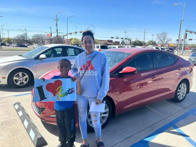 Happy celebrating their car purchase at the dealership.
